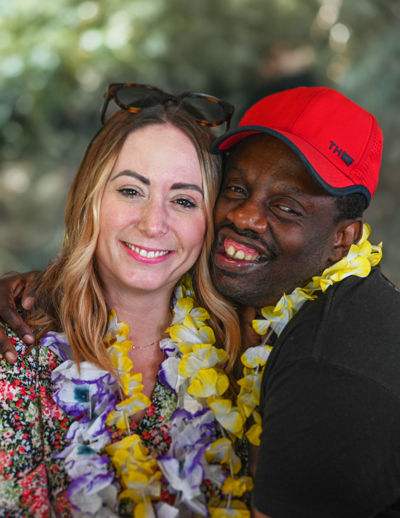 smiling woman and man wearing colorful leis