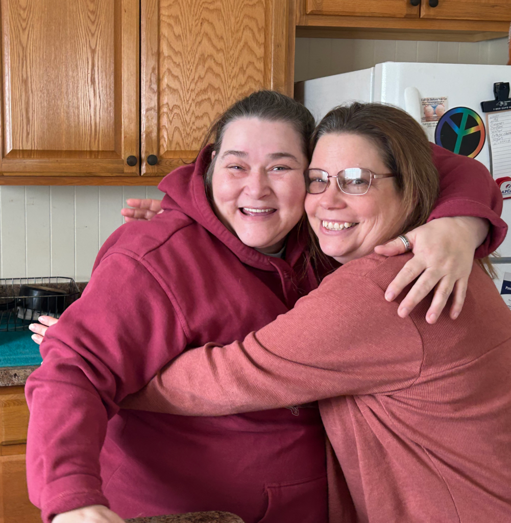 Tina Clark (left) hugs Unity House Residence Counselor Catherina Meyers during a check-in meeting at Tina's apartment in Auburn.