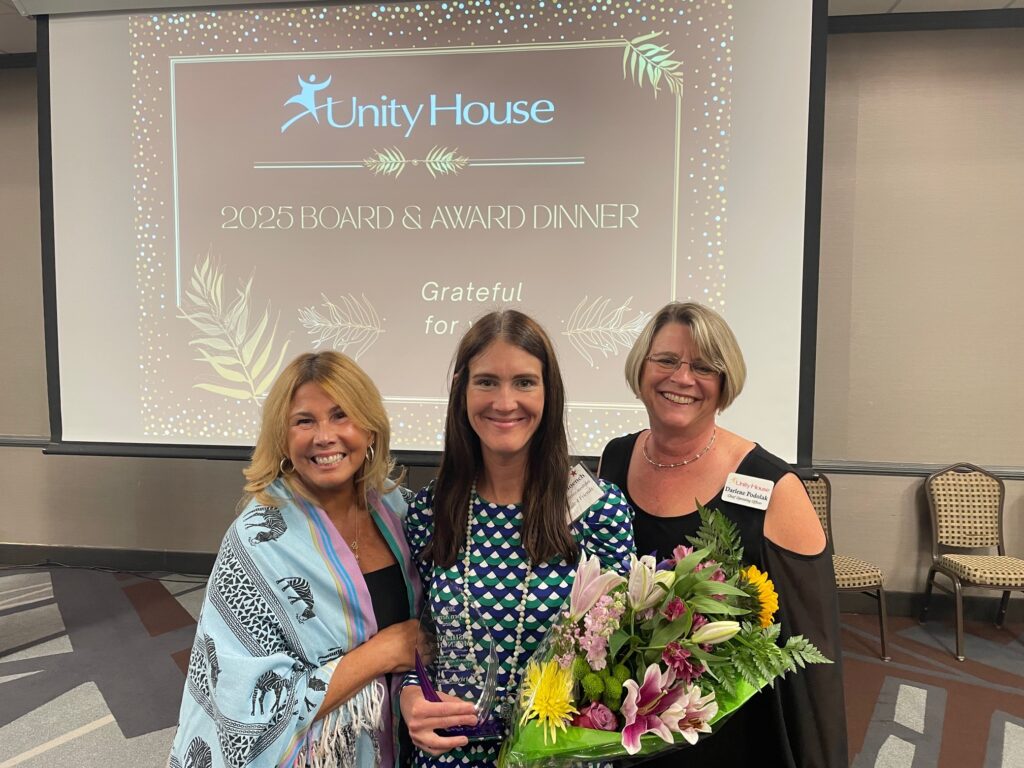 CEO Liz Smith (left) and COO Darlene Podolak (right) stand alongside 2025 Open Arms awardee and executive director of Nick's Ride 4 Friends, Ashley Moench.